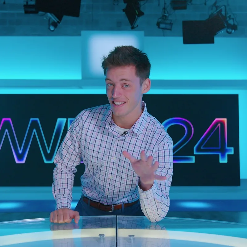 Frank Palmieri, founder of Frank Palmieri Media, at a television news anchor desk.